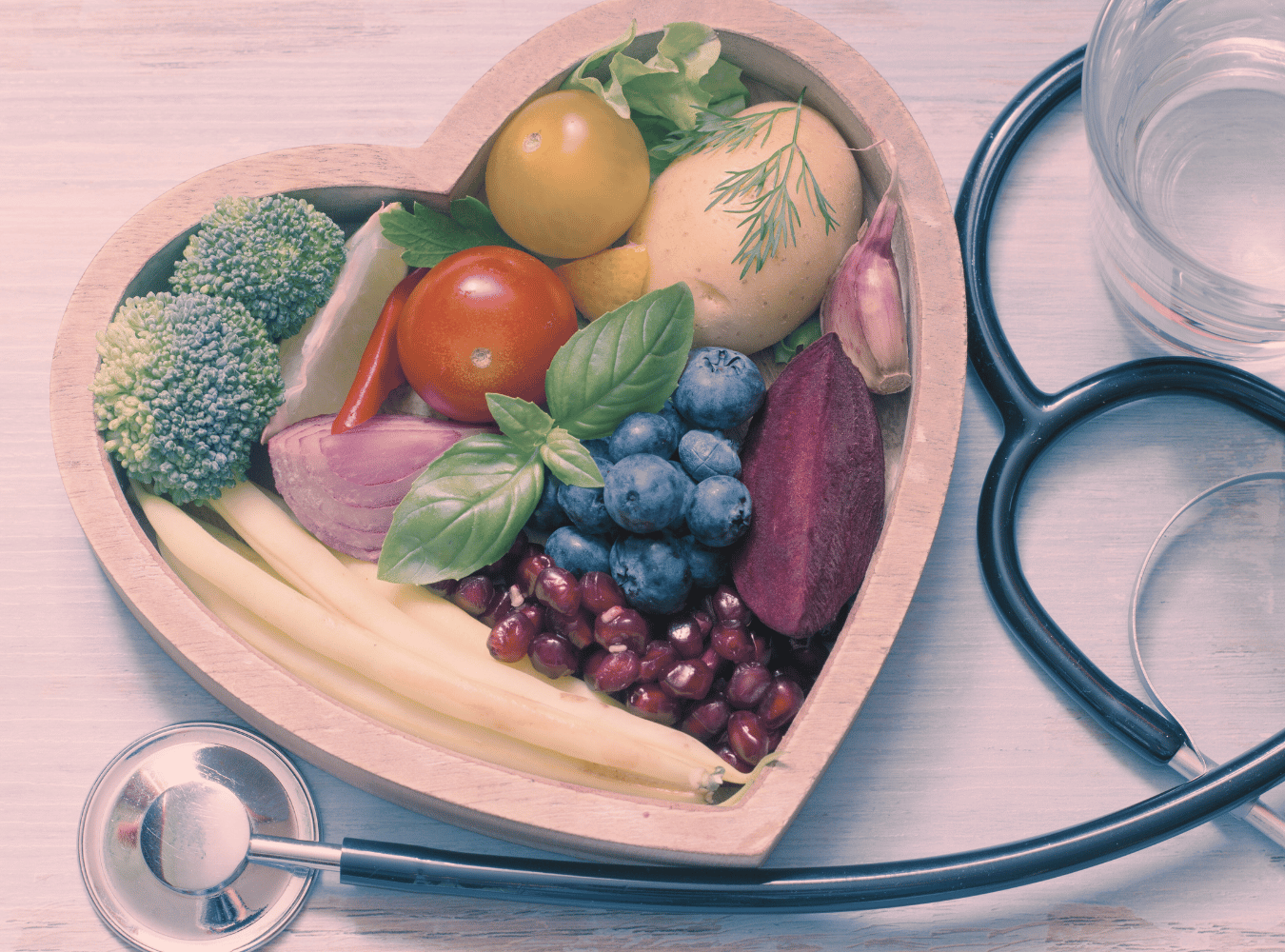 Transparency in food as medicine photo of fruit and vegetables in heart shaped bowl next to stethoscope