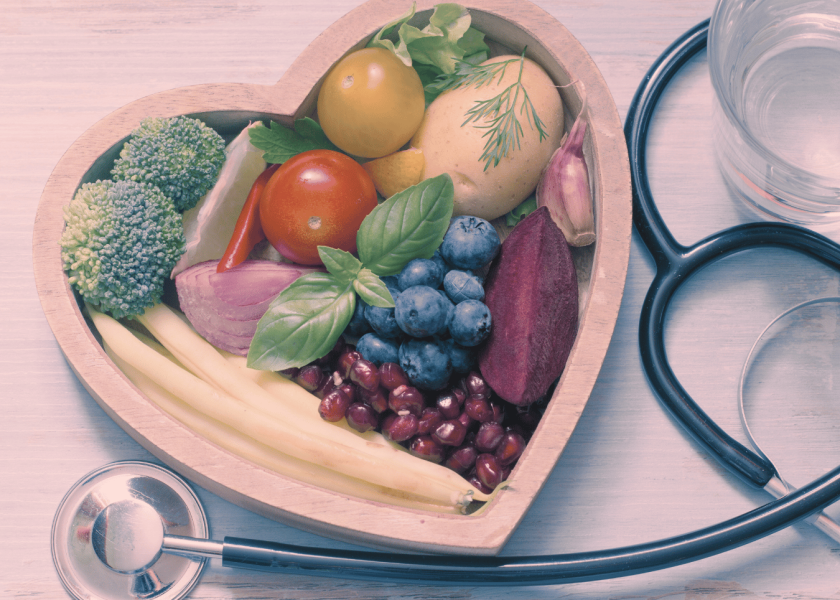 Transparency in food as medicine photo of fruit and vegetables in heart shaped bowl next to stethoscope
