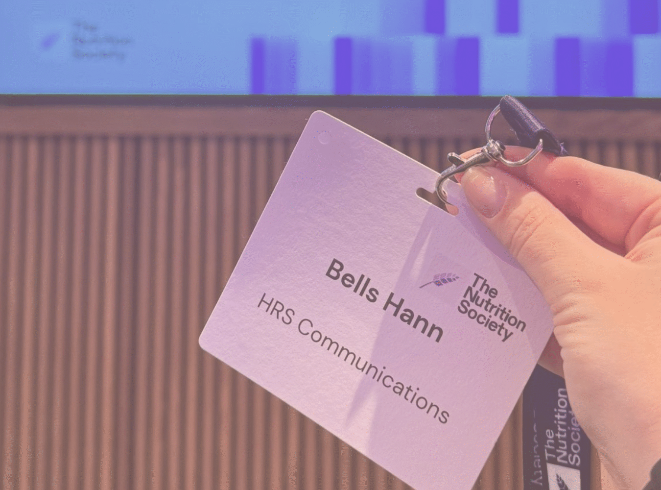 Bells hand holding her name badge at the event